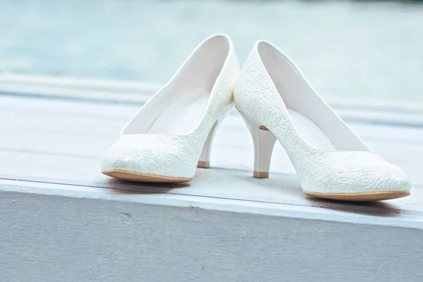 Sapatos de casamento branco no fundo de madeira — Fotografia de Stock