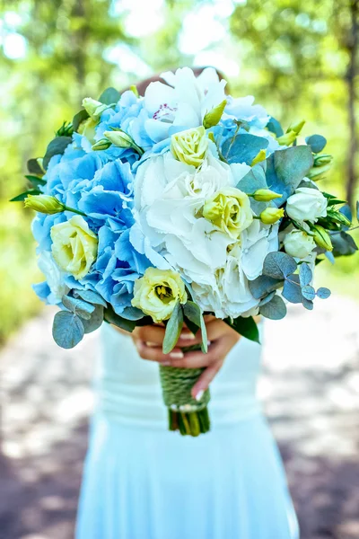 Vrouw met blauwe en witte bloem als geschenk op zonnige — Stockfoto
