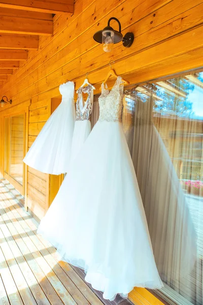 La robe de mariée parfaite suspendue à l'extérieur de la maison en bois — Photo