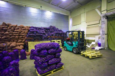 Bags and crates of potato in warehouse clipart