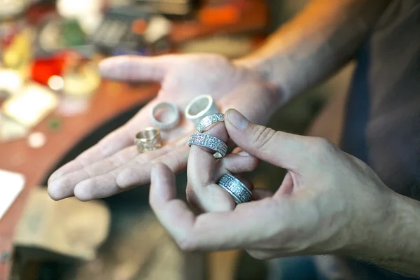 Man handling the handmade rings at jewelry workshop — Stock Photo, Image