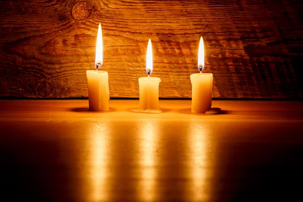 Pozadí s světle svíček na dřevěné desce na noc — Stock fotografie