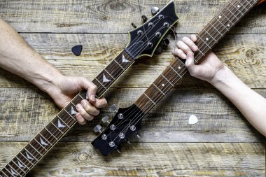 Baba oğul elektro gitar tutuyorlar.
