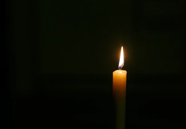 Isolate burning candle on dark background — Stock Photo, Image