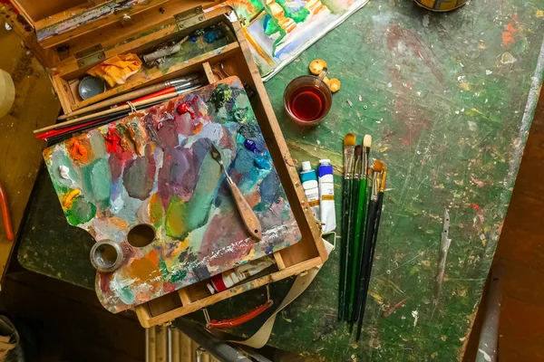 Workplace of the artist with brushes and oil paints — Stock Photo, Image