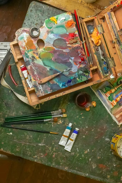 Pracoviště na umělce s kartáčky a olejové barvy — Stock fotografie