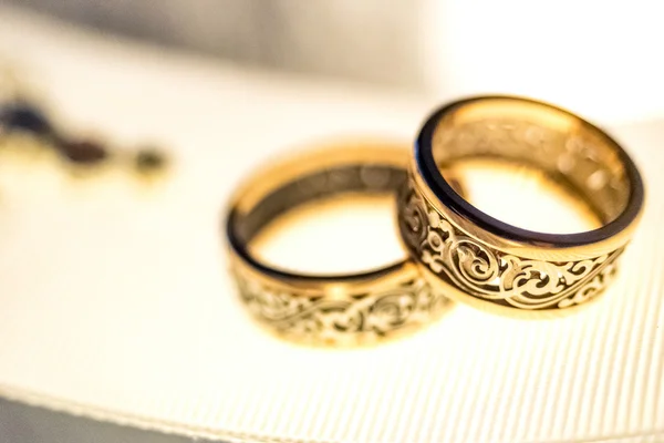 Свадебные золотые кольца на белой ленте — стоковое фото