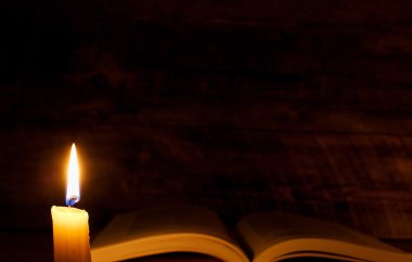 mum ışığında ahşap bir masa kitap