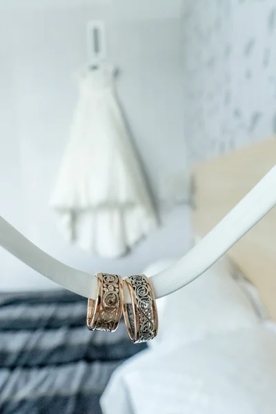 Two rings with rare design in front of wedding dress