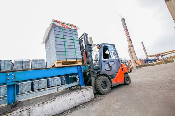 Autolader met betonblokken in de buurt van woningbouwfabriek — Stockfoto