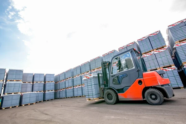 Auto loader with concrete blocks near house-building factory