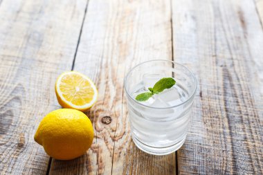 Tahta masada limonlu ve naneli bir bardak su.