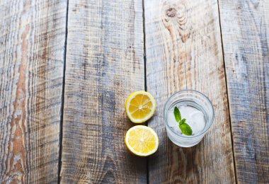 Lemonade with fresh lemon and mint on wooden background clipart