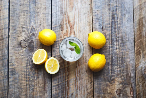 Lemonade with fresh lemon and mint on wooden background — Stock Photo, Image