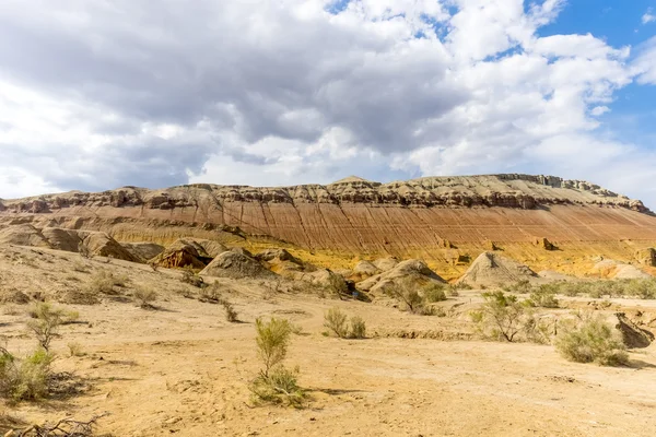 Montagna rocciosa nel deserto sotto cielo nuvoloso — Foto Stock