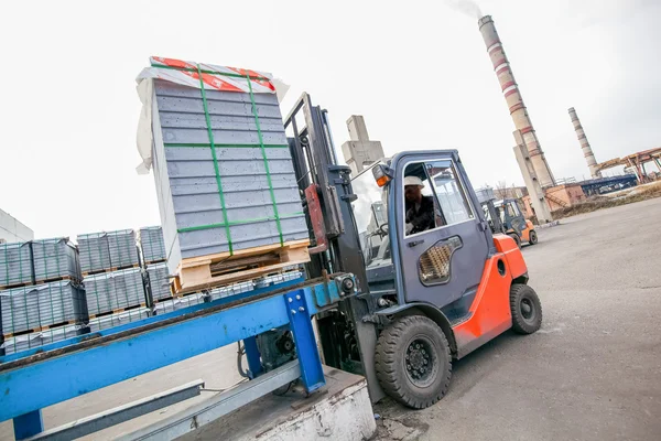 Ładowarka samochodowa z blokami betonowymi w pobliżu fabryki domów — Zdjęcie stockowe