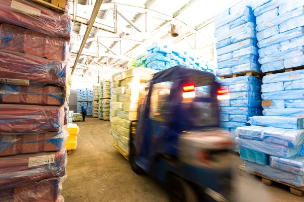 Armazém com empilhadeira e pilhas de caixa na fábrica — Fotografia de Stock