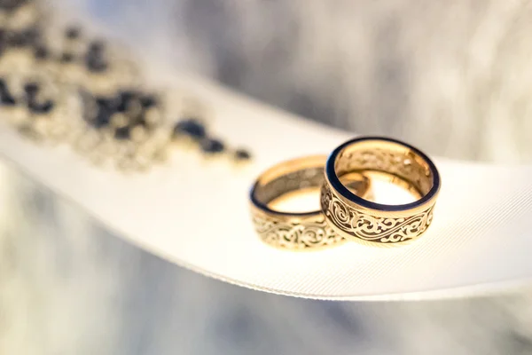 Два обручальных кольца с редким дизайном на белой широкой ленте — стоковое фото