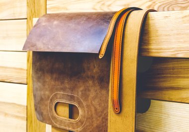 Tahta kirişlerde asılı deri boş çanta.