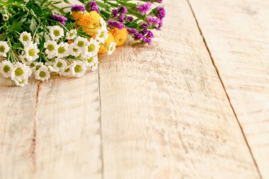 Tahta masada bahar çiçekleri ve papatyalar