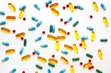 Beyaz arka planda izole edilmiş renkli tıbbi haplar.