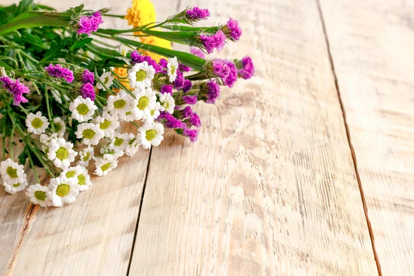 Tahta masada bahar çiçekleri ve papatyalar