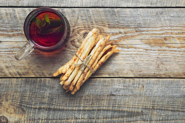 Montón de palitos de pan con té en la mesa de madera —  Fotos de Stock