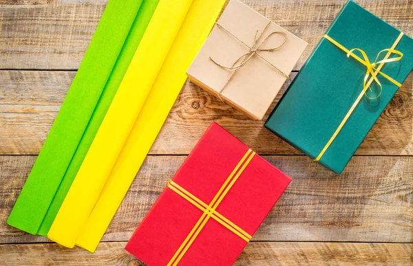 Colored gift boxes on wooden background with ribbon — Stock Photo, Image