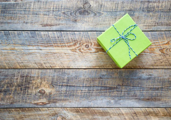 small green gift box on empty wooden table