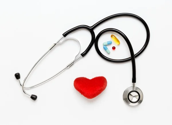 A fehér háttér, plüss szív és tabletták sztetoszkóp — Stock Fotó
