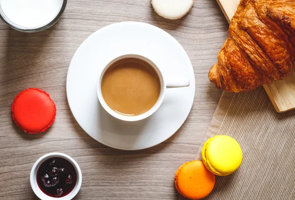 Sweet breakfast with coffee, macaroons and croissants on wooden table — Stock Photo, Image