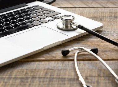 Doktor çalışma alanı ile bir stetoskop ve ahşap masa laptop