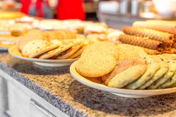 Verschillende soorten zoete gebakjes op platen — Stockfoto