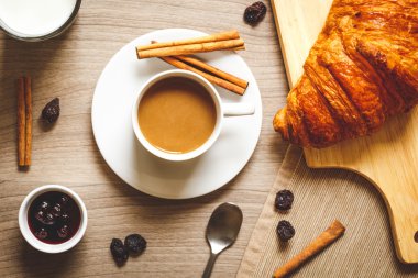 kruvasan ahşap masa üstüne tatlı kahvaltı kahve ile göster