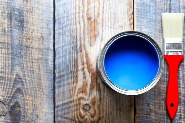 Картина с банкой синей краски на деревянном фоне вид сверху — стоковое фото