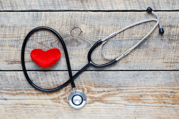 New stethoscope with plush heart on wooden table — Stock Photo, Image