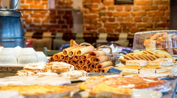 Verschillende soorten zoete gebakjes op platen in café — Stockfoto