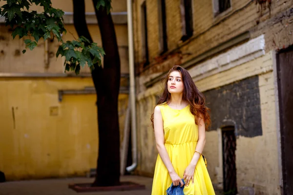 Young girl on city streets in summer in yellow dress — Stock Photo, Image