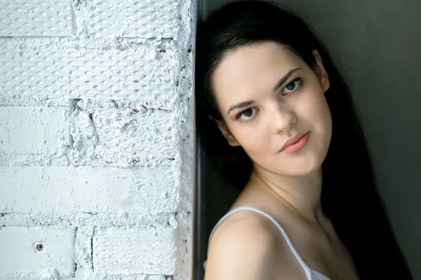 kız beyaz tuğla duvara yakın ayakta portresi