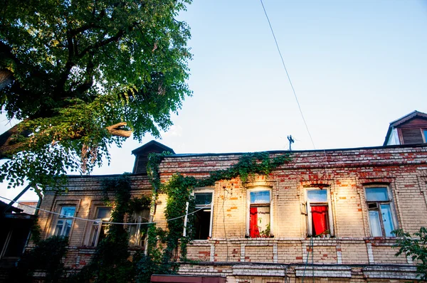 Фасад кам'яного будинку з вікнами і червоними шторами — стокове фото