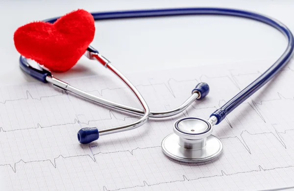 Estetoscópio sobre fundo branco com coração de pelúcia e cardiograma — Fotografia de Stock