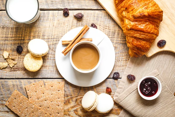 咖啡、 饼干和木制的桌子上的羊角面包一起吃早餐 — 图库照片
