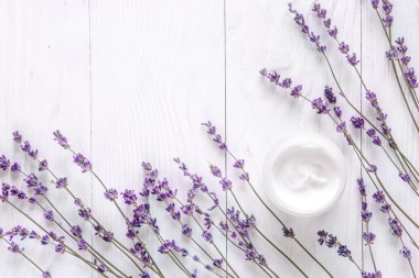 Ahşap arka plan üzerinde lavanta ve yüz kremi