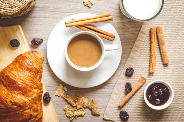 Breakfast with coffee and croissants on wooden table — Stock Photo, Image