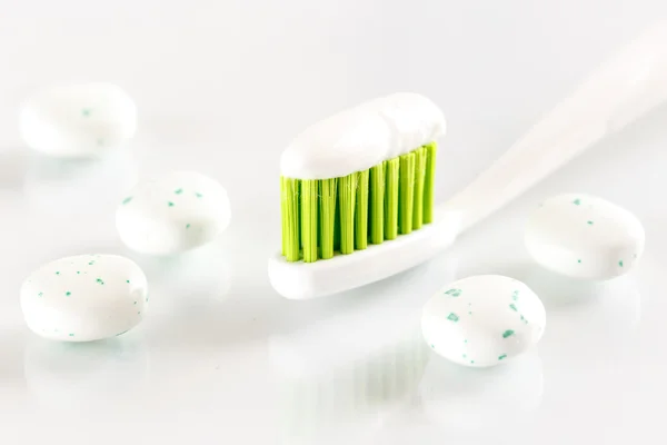 Sqweezed grön tandborste på vit bakgrund med bubbla tandkött — Stockfoto