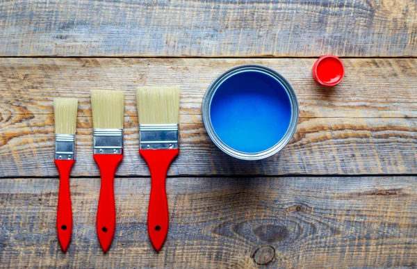 Pittura con lattina vernice blu su sfondo di legno — Foto Stock