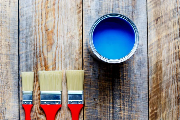 Pittura con lattina vernice blu su sfondo di legno — Foto Stock