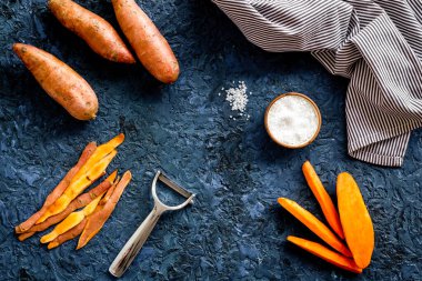 Kesme tahtasında dilimlenmiş tatlı patates, üst manzara.
