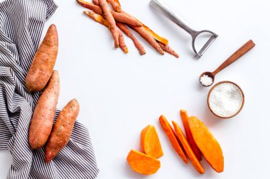 Kesme tahtasında çiğ portakallı tatlı patates, üst manzara.