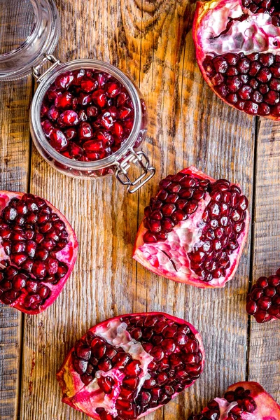 Skivad granatäpple på trä bakgrund ovanifrån — Stockfoto